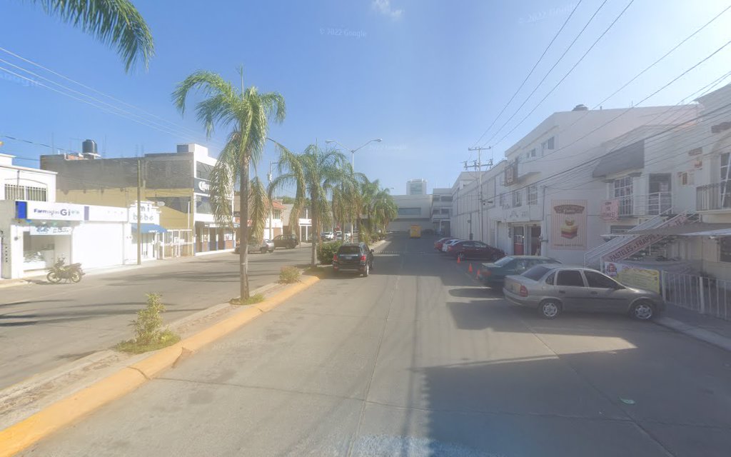 Dentista infantil en España - Una tranquila calle urbana de Irapuato bordeada de palmeras, coches aparcados y edificios de poca altura que incluyen tiendas, comercios y una odontopediatra en Irapuato bajo un cielo azul despejado. | Clínica dental pediátrica Dentistainfantilcercademi