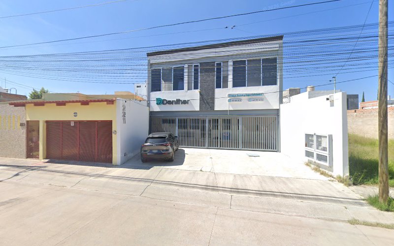 Dentista infantil en España - Un moderno edificio de dos plantas con los rótulos Dentalia y Consultorios Dentales en la fachada. Hay un coche gris aparcado delante, y la zona es tranquila, con casas vecinas y cables aéreos de servicios públicos. | Clínica dental pediátrica Dentistainfantilcercademi